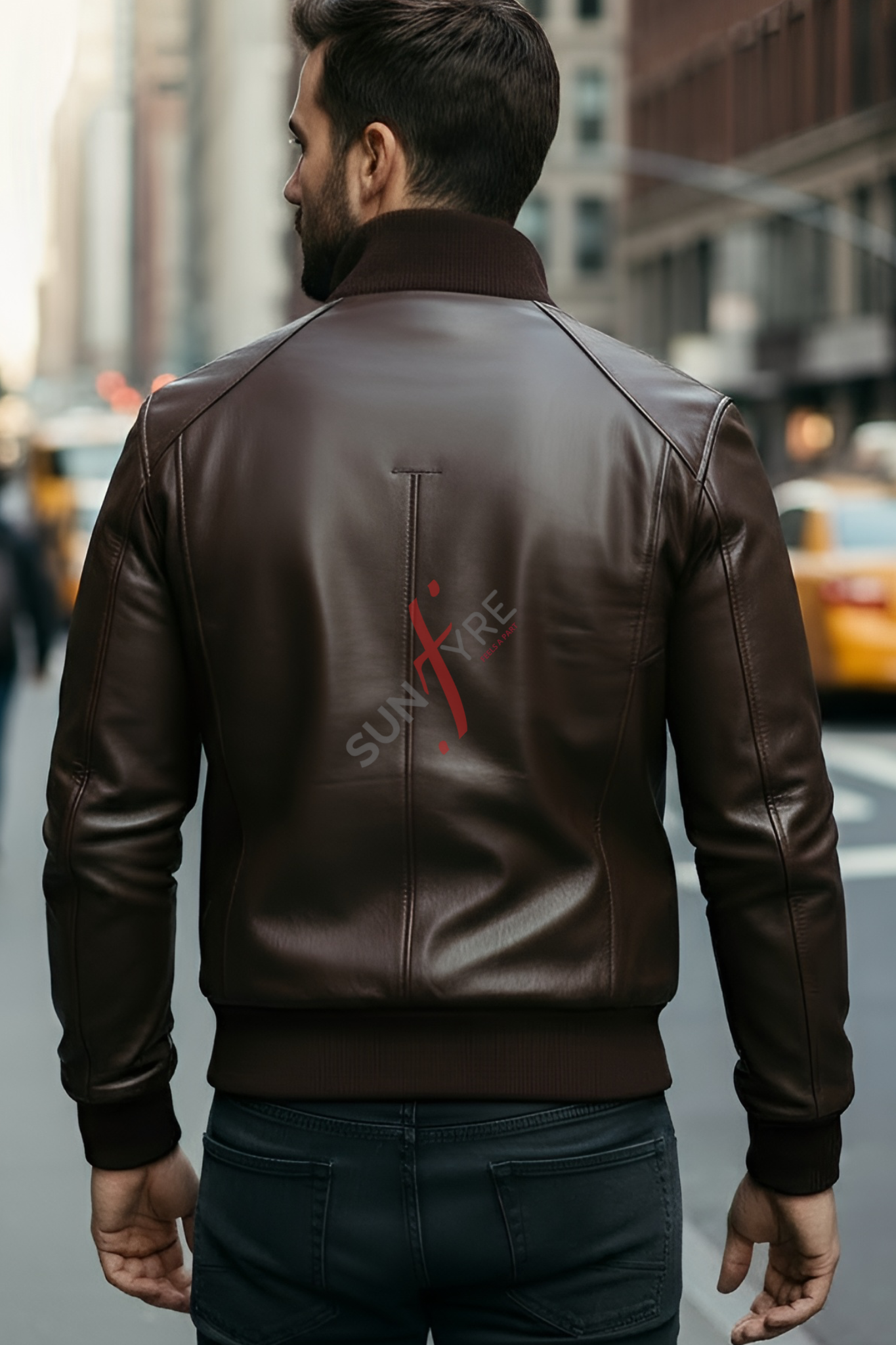 Man wearing a brown leather jacket with a visible brand logo on a city street.