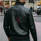 Man wearing a black leather jacket with a brand logo in an urban setting