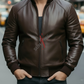 Man wearing a brown leather jacket with a blurred city street background