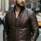 Man wearing a brown leather jacket with a brand logo on a city street.