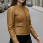 Woman wearing a tan leather jacket on a city street