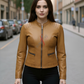 Woman wearing a tan leather jacket on a city street