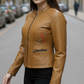 Woman wearing a brown leather jacket on a city street