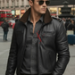 Man wearing a black leather jacket and sunglasses on a city street.