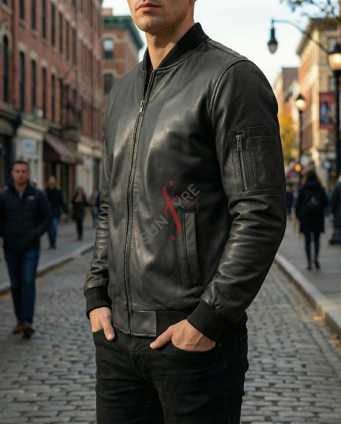 Man wearing a black leather jacket with a red logo on a city street.