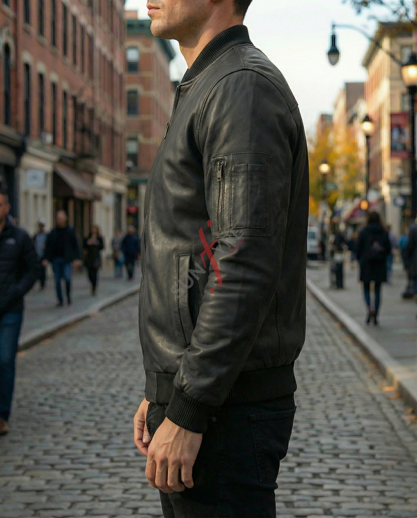Man wearing a dark leather jacket with a red cross on a city street.