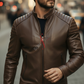 Man wearing a brown leather jacket and sunglasses on a city street.