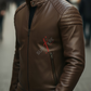 Man wearing a brown leather jacket with a brand logo on a blurred background