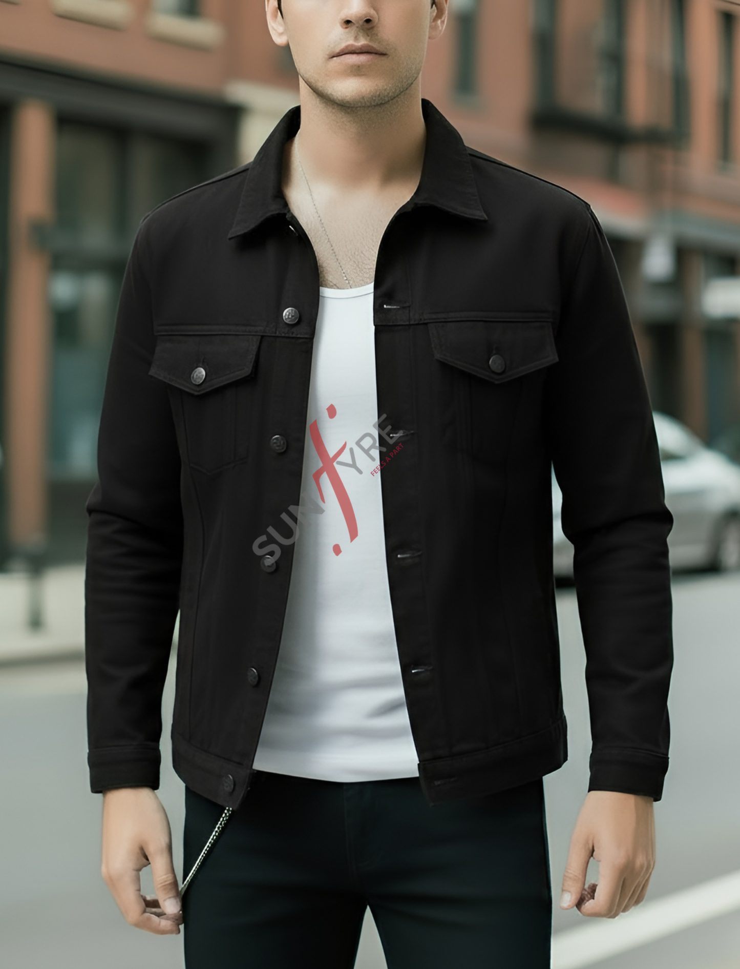 Man wearing a black jacket over a white shirt with red text on a street.