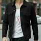 Man wearing a black jacket over a white t-shirt with red text on a blurred street background