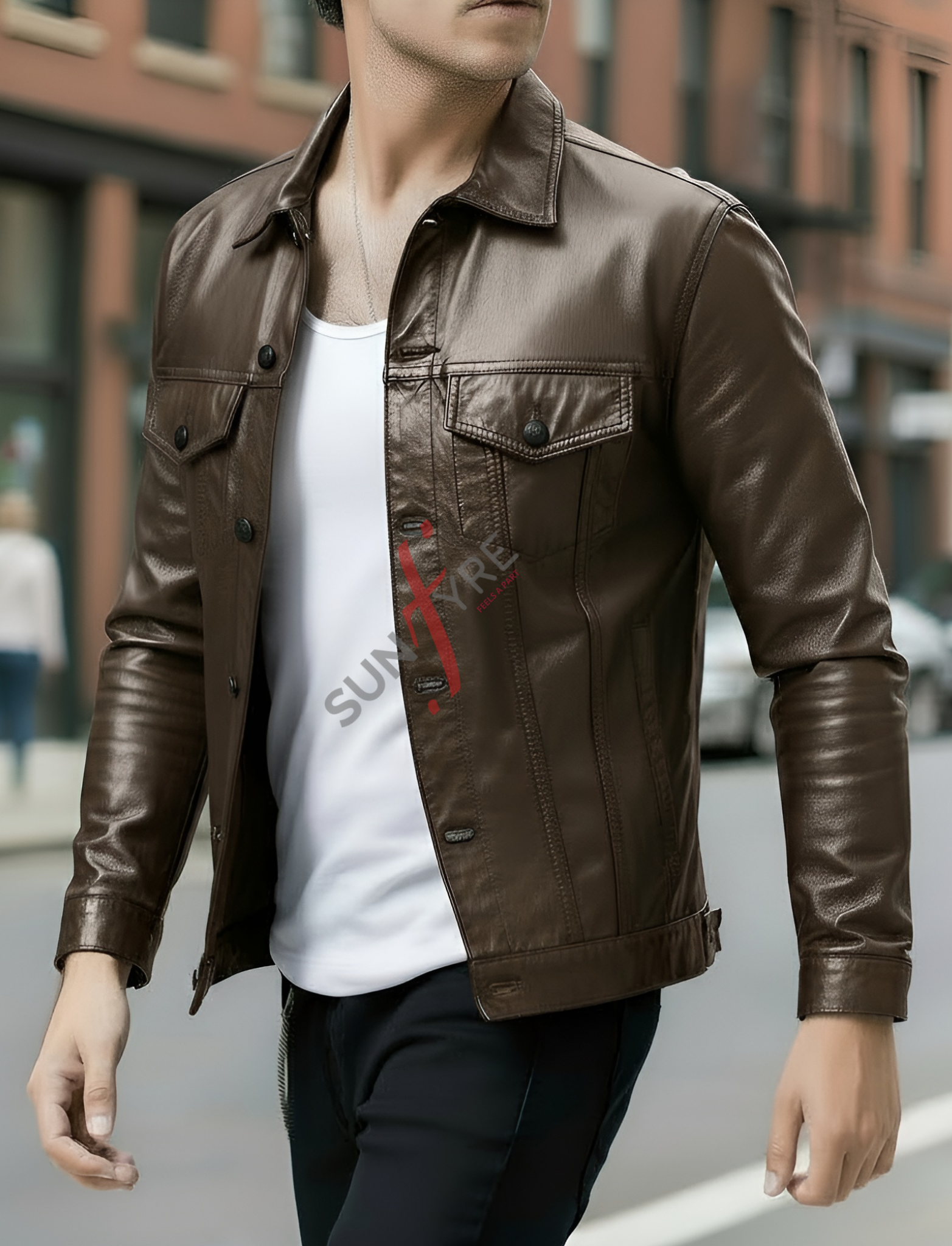Person wearing a brown leather jacket over a white shirt with a red logo, standing on a street.