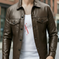 Person wearing a brown leather jacket over a white t-shirt with red graphics, standing in an urban setting.