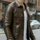 Person wearing a brown leather jacket with a visible brand logo on a city street.