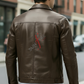 Man wearing a brown leather jacket with a red logo on a city street