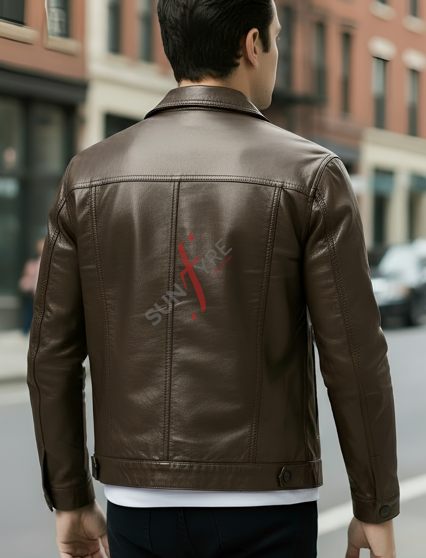 Man wearing a brown leather jacket with a red logo on a city street