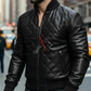 Man wearing a black leather jacket with a brand logo in an urban setting