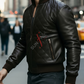 Man wearing a black leather jacket with a brand logo on a city street