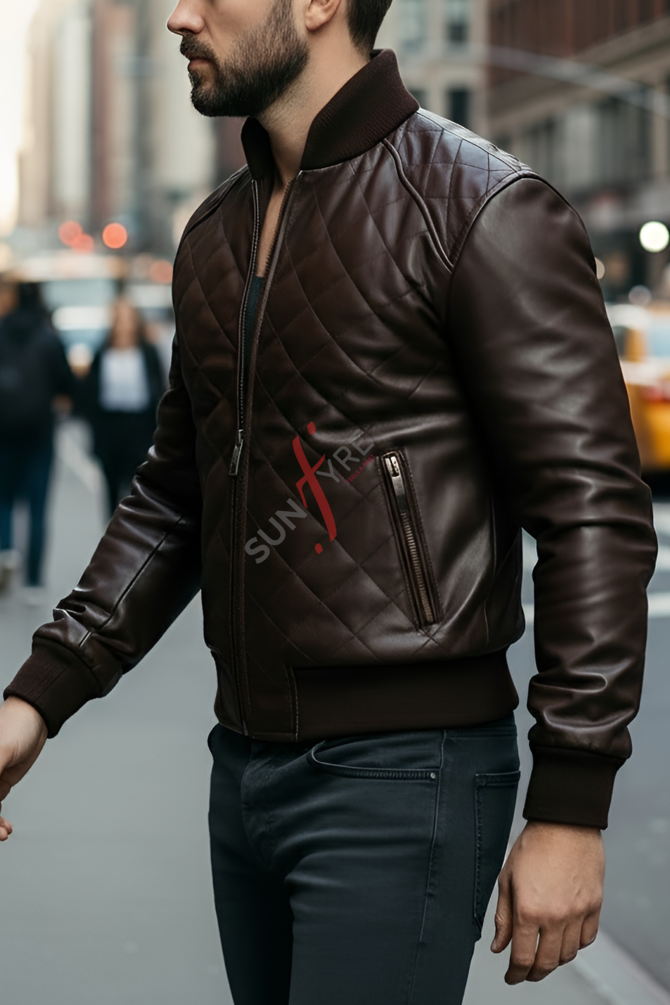 Man wearing a brown leather jacket with a brand logo on a city street.