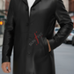 Black leather coat with a brand logo on a blurred street background