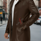 Man wearing a brown leather coat on a city street with 'Sunfire' logo.