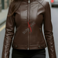 Woman wearing a brown leather jacket with on a blurred street background
