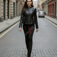 Woman wearing a black leather jacket and pants on a city street