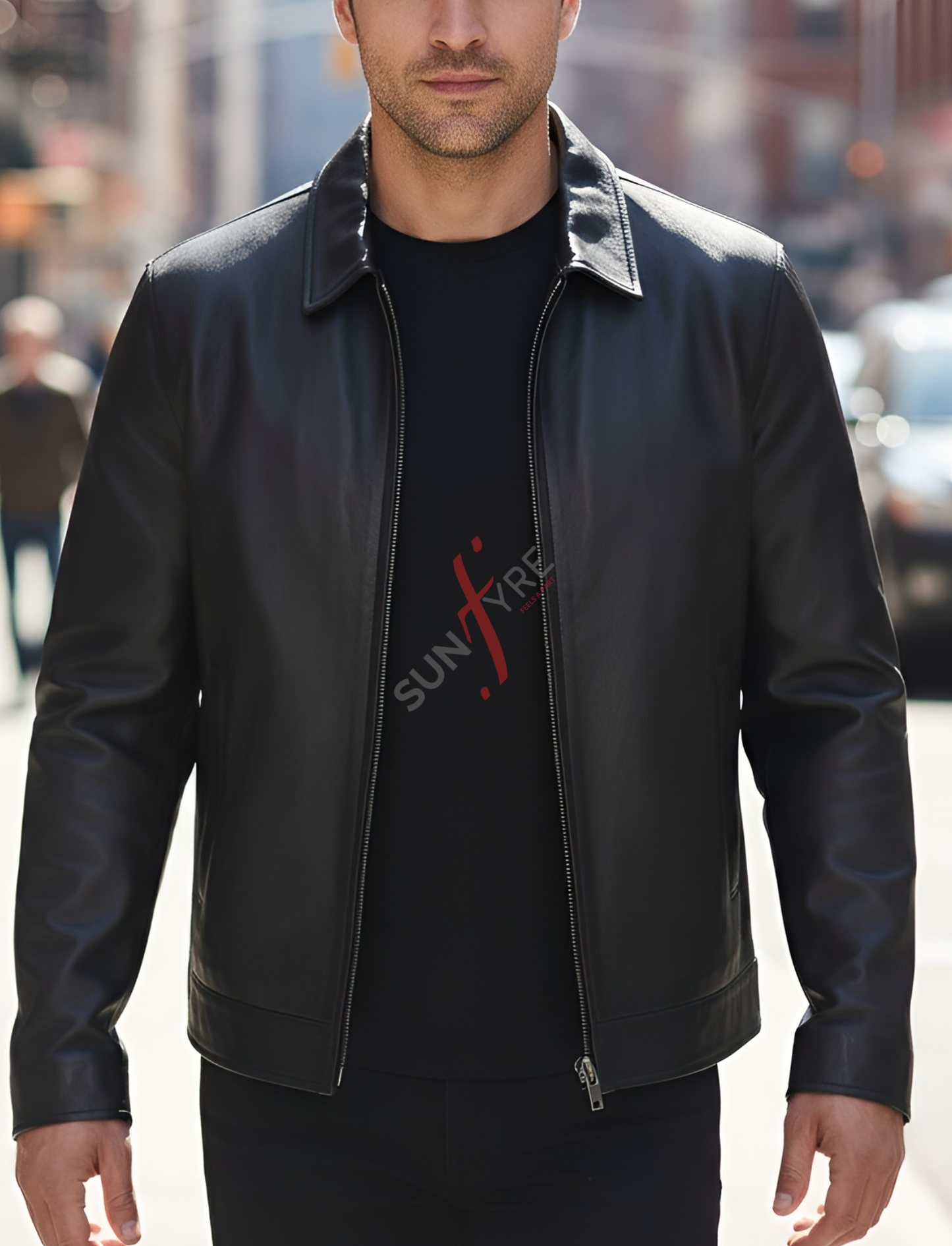Man wearing a black leather jacket over a black t-shirt with a logo, standing in an urban setting.
