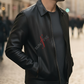 Man wearing a black leather jacket with 'Sunfire' logo on a blurred street background