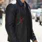 Man wearing a black jacket with 'Suntire' logo on a city street