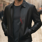 Man wearing a black leather jacket with a brand logo on a blurred street background
