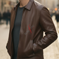 Man wearing a brown leather jacket with 'SUNYRE' logo on a blurred street background