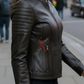 Woman wearing a black leather jacket on a city street with logo.
