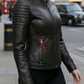 Woman wearing a black leather jacket on a city street