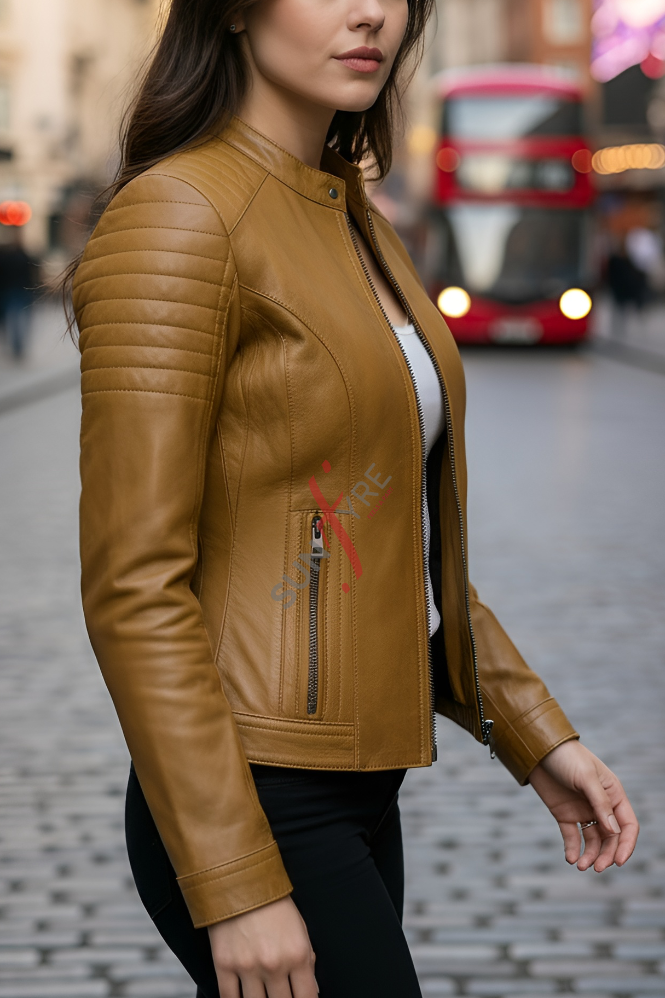 Woman wearing a cognac leather jacket on a city street with a blurred background