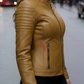 Woman wearing a cognac leather jacket on a city street.