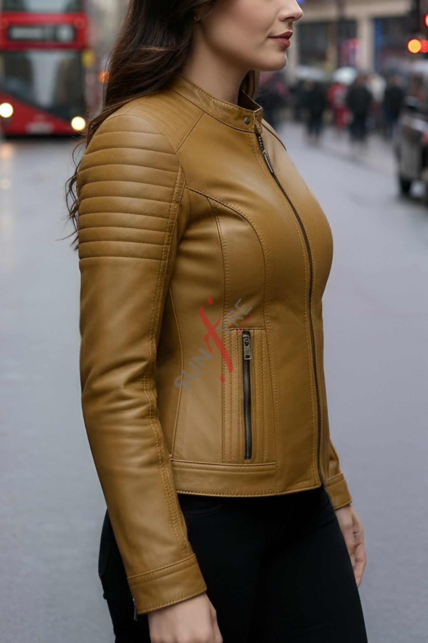 Woman wearing a cognac leather jacket on a city street.